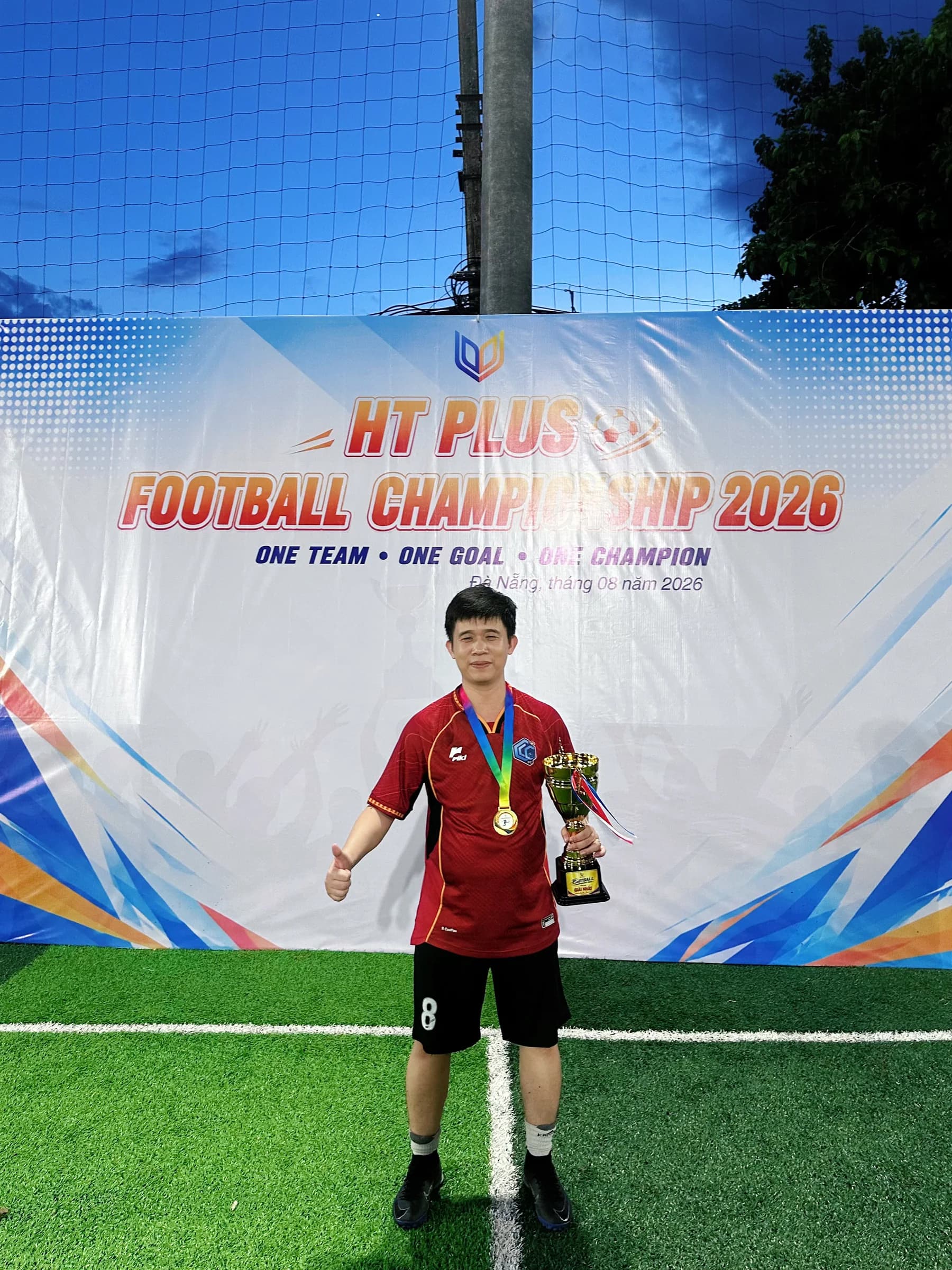 Cầu thủ số 8 CLC FC chụp ảnh với cúp vô địch