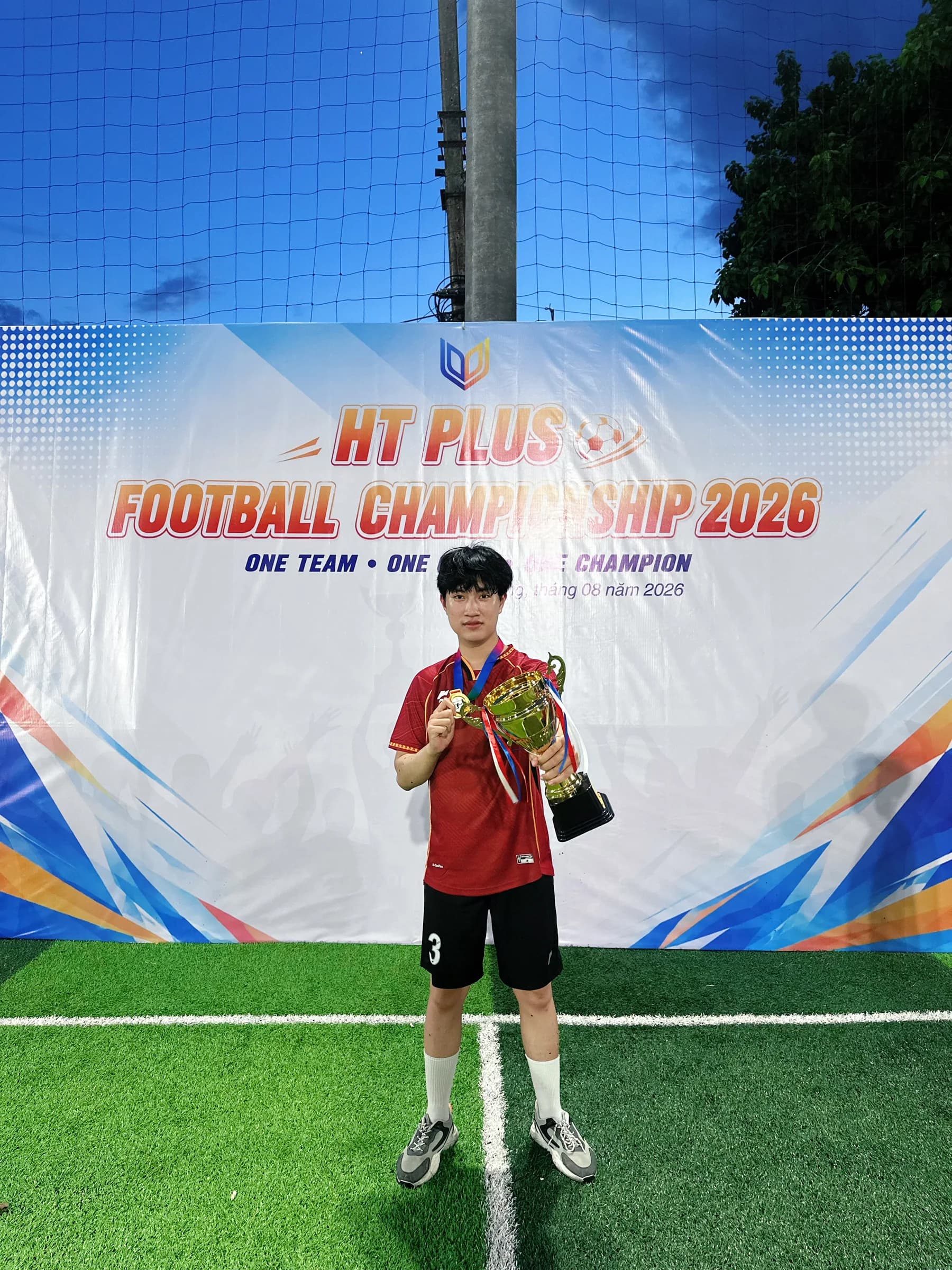 Cầu thủ số 3 CLC FC chụp ảnh với huy chương và cúp