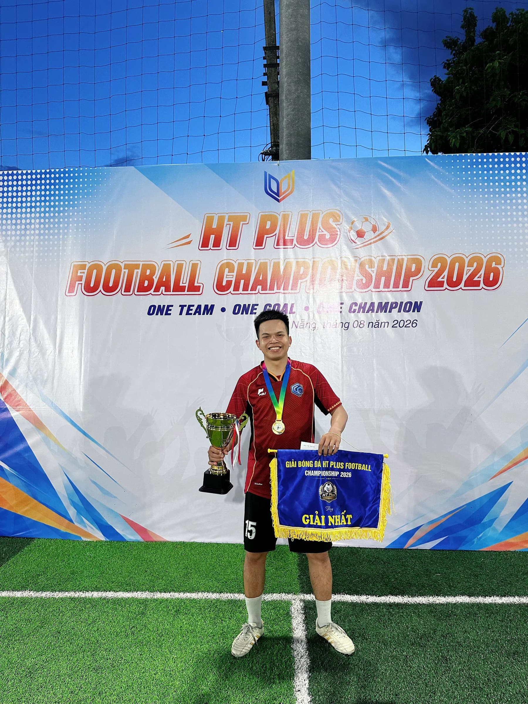 Cầu thủ số 15 CLC FC chụp ảnh với cúp vô địch